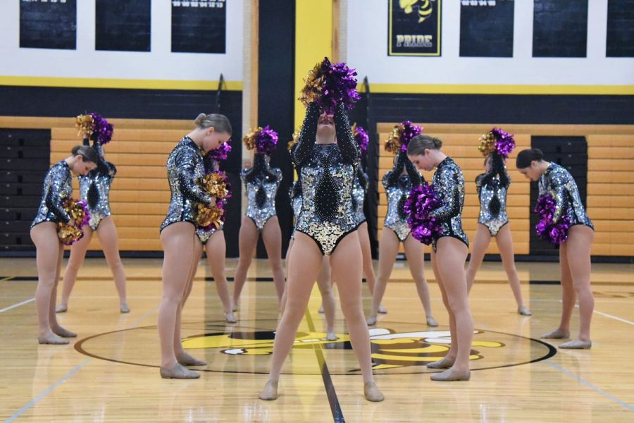 The Varsity Danceline at Conference in the opening formation of their poms routine. Masks are required at all times unless the team is performing or taking photos. 
