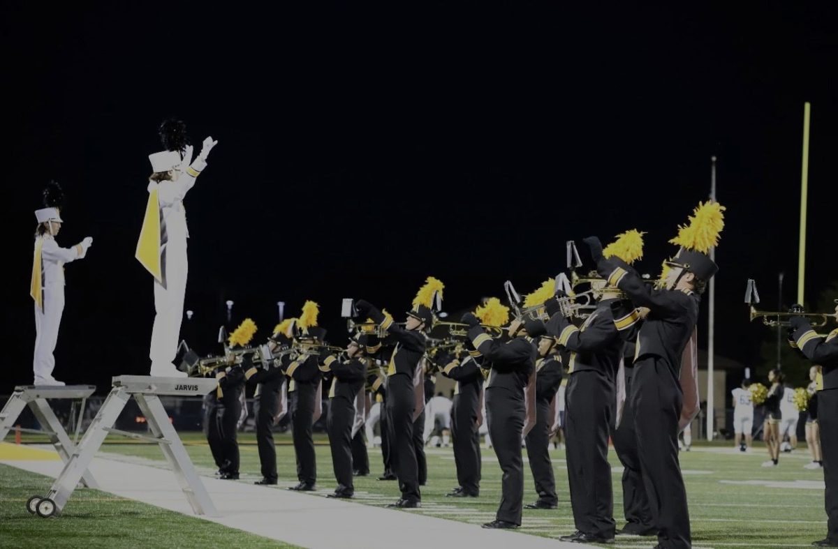Josh Byrd and Emma Koelling conducting the Hinsdale South Marching Band at a home football game.