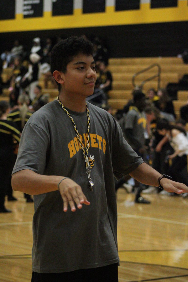 Aiden Yen, the drum major leading the band as they play for the assembly.