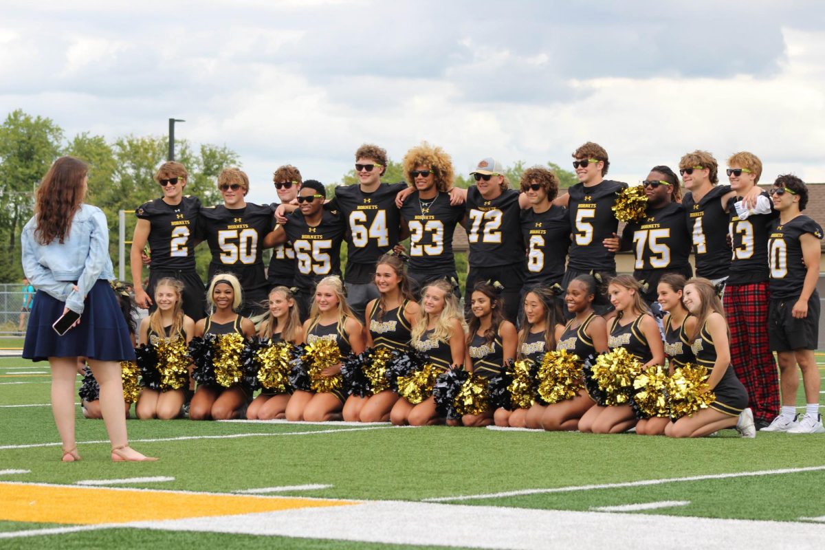 Both varsity Football, and varsity cheer posting for a photo.