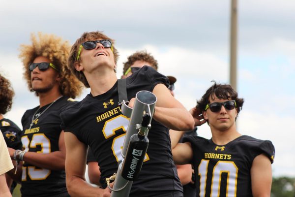 Varsity football players using the t-shirt cannon to help encourage the crowd to particpate.