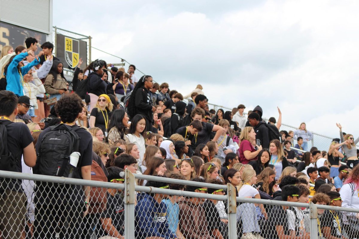 Students within the crowd stand up as they try to catch t-shirts from the cannon and the t-shirt launcher