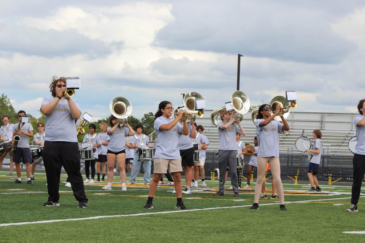 The marching band as it plays along the field bringing a wonderful show to the rally.