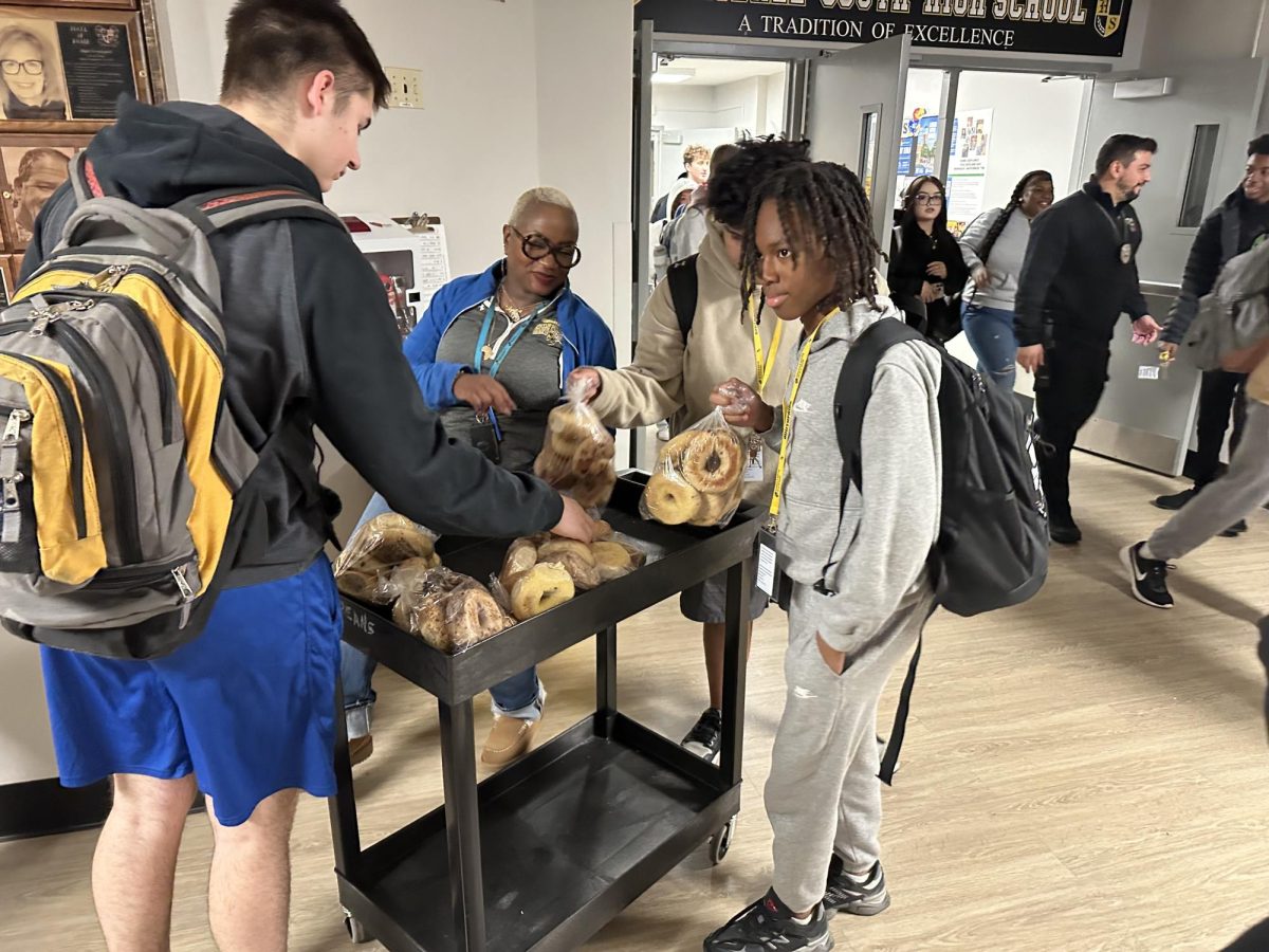 Ms. Truman handing out bagels to students at the end of the school day