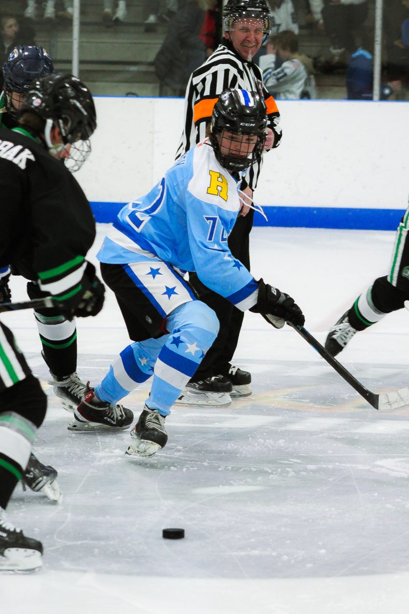 Team Captain and Hinsdale South senior Devin Casey, as he attempts to sway the game in the Stars favor by trying bringing the puck towards the Spartans goal and away from the Stars goal.