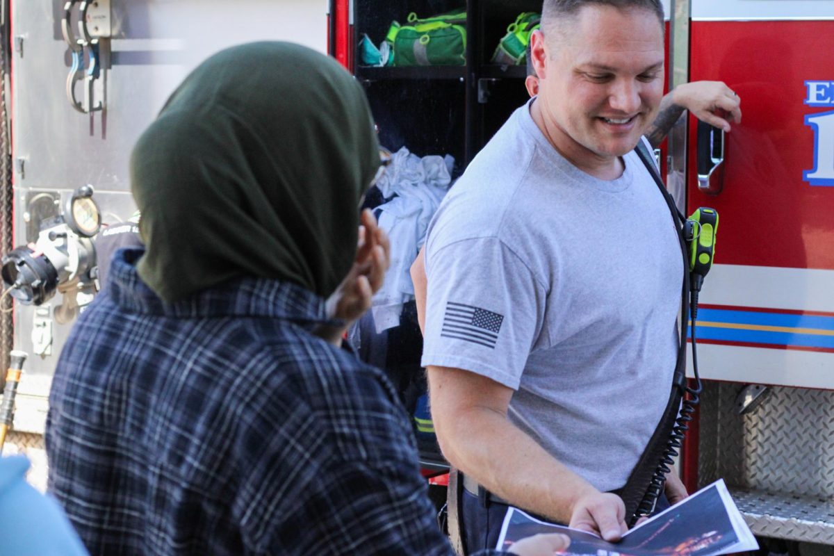 During the event Lt Dave Davis shows photos of the firetruck to (Sophmore) Nuha Kassem, September 18th 2025