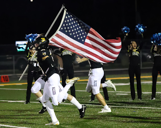 South football player shows patriotism by running with the US flag during the homecoming game 